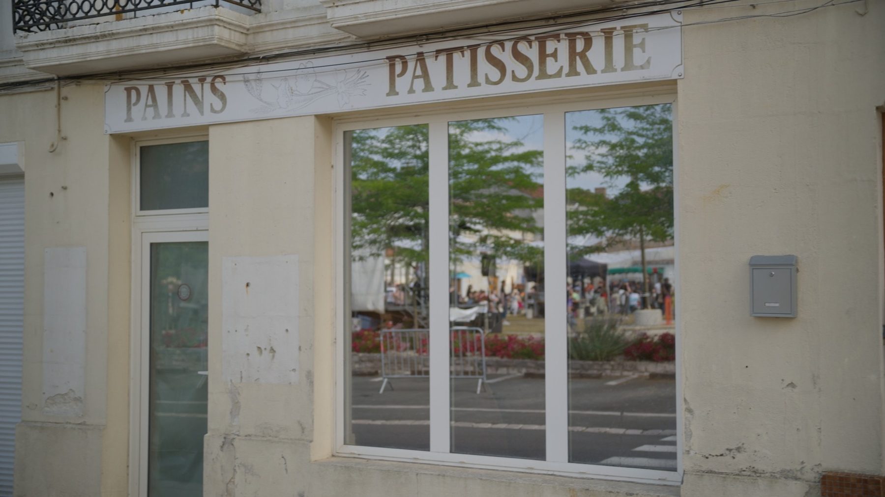 Lieu Dire : la devanture d'une ancienne boulangerie, le festival se reflète dans la vitrine.